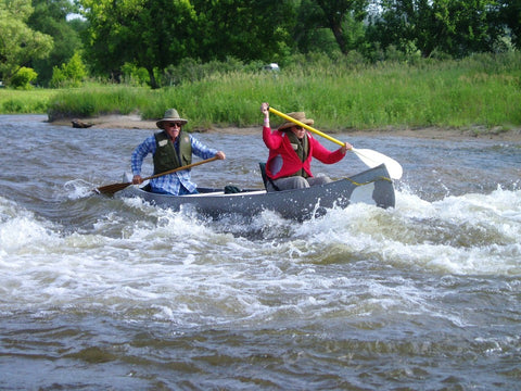 Couple in Canoe Going Down Rapids