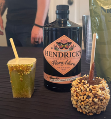 Carmel Flowers drink with Hendricks gin bottle and caramel apple