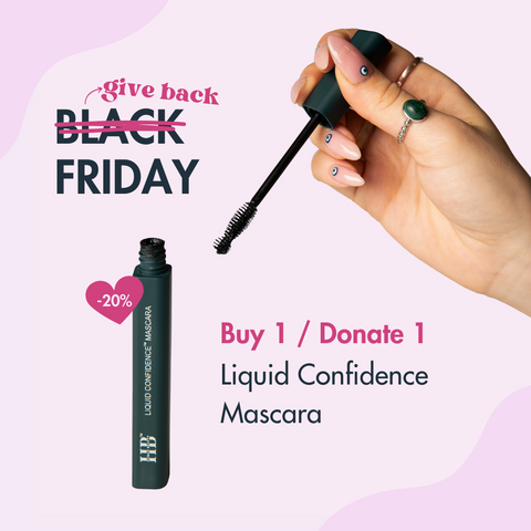 An image of the Liquid Confidence Mascara open, with a hand holding the wand. Below the hand is "Buy 1/ Donate 1" "Liquid Confidence Mascara"