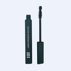 Human Beauty's Liquid Confidence Mascara. A dark green makeup tube with white writing, it is opened with the wand standing next to the tube