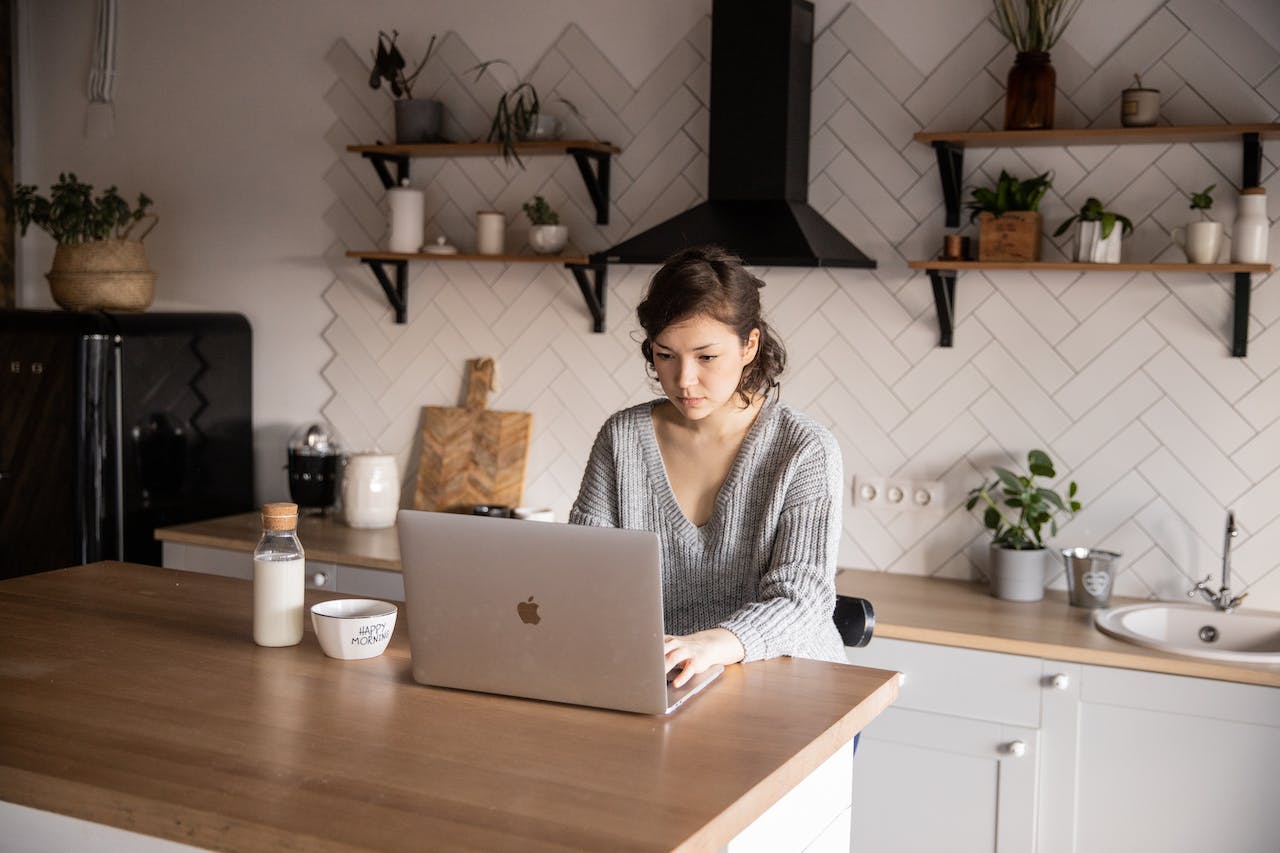 persona en cocina con laptop en ecommerce