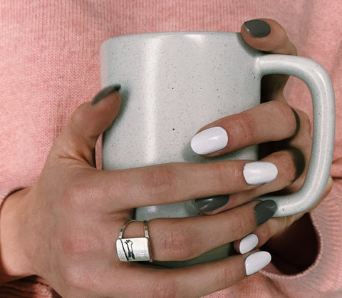 Beth Millner Jewelry Fox on a Starry Night Ring on hands holding a mug