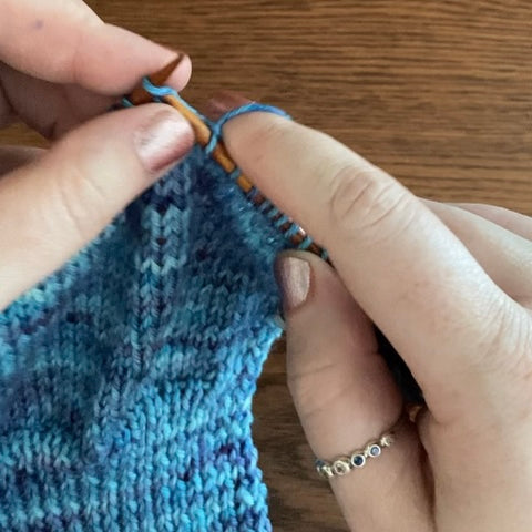Ambassador Rebecca knitting and wearing a Pride Ring from Beth Millner Jewelry