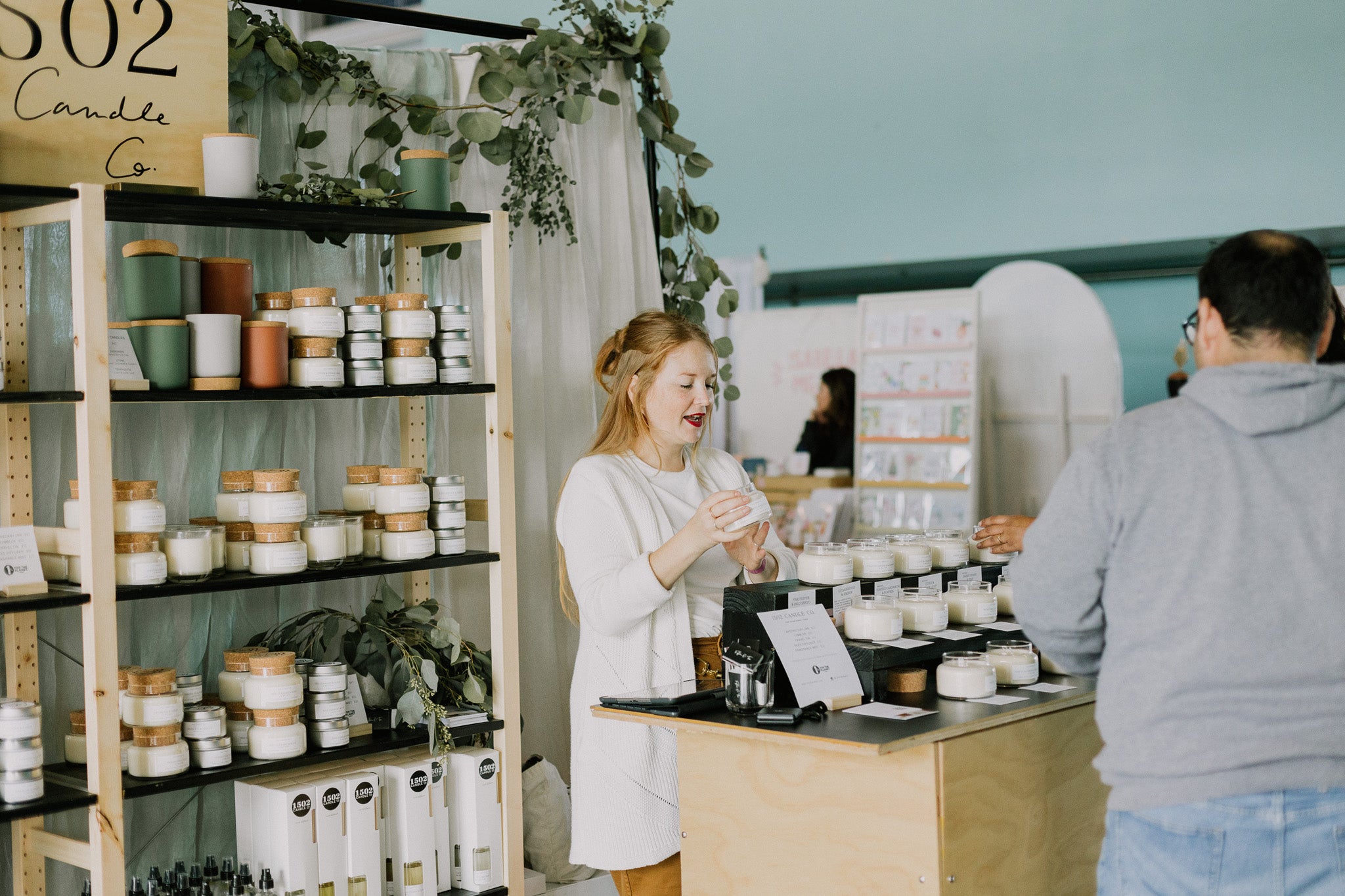 A shopper paying for their candles from 1502 Candle Co.