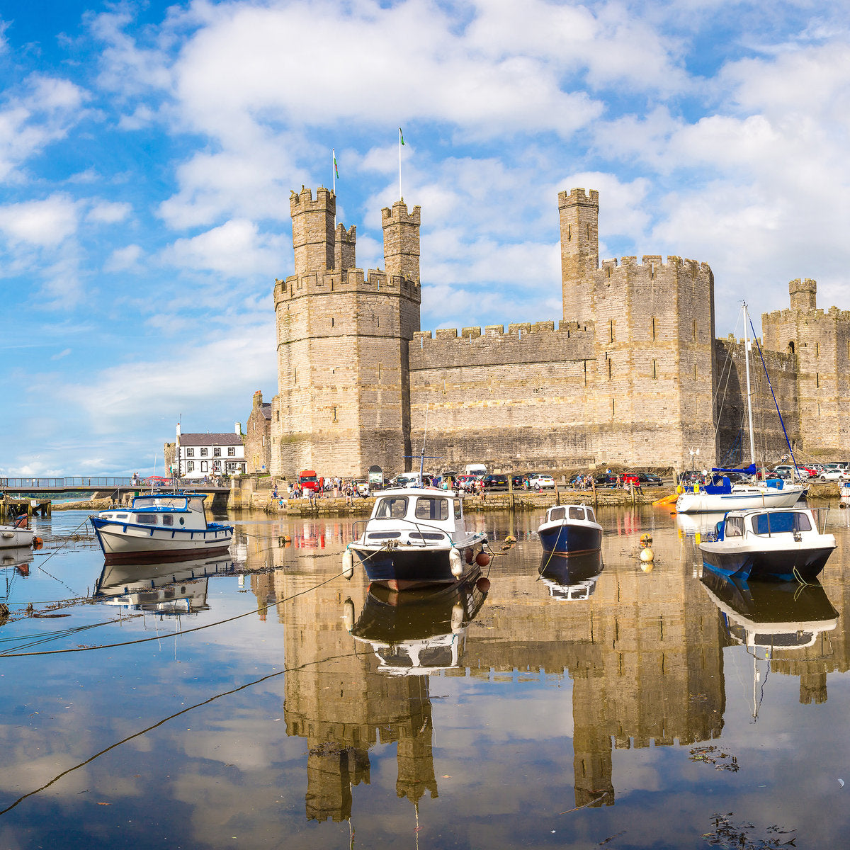 Beside the water in Caernarfon, with fishing boats in the foreground and the castle in the background