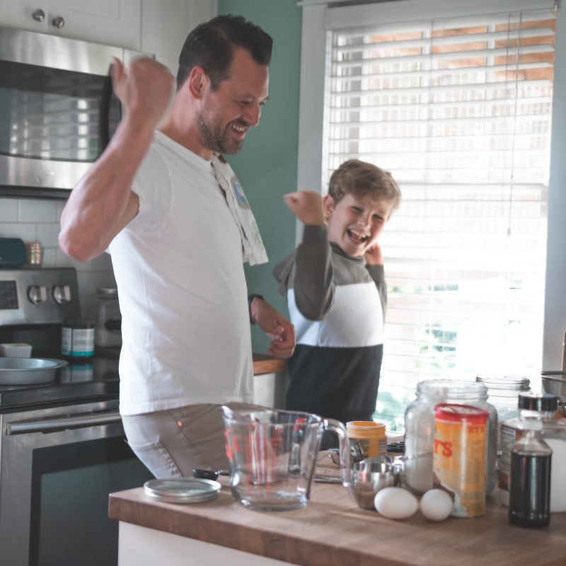 Father and son dancing in the kitchen while baking | Stay Active with Treasure Trails