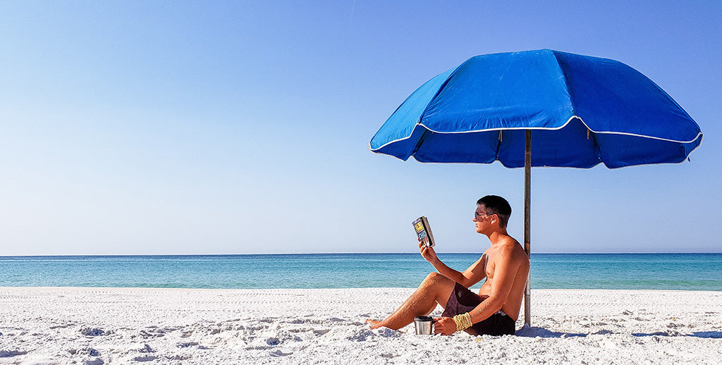 man on the beach under an umbrella