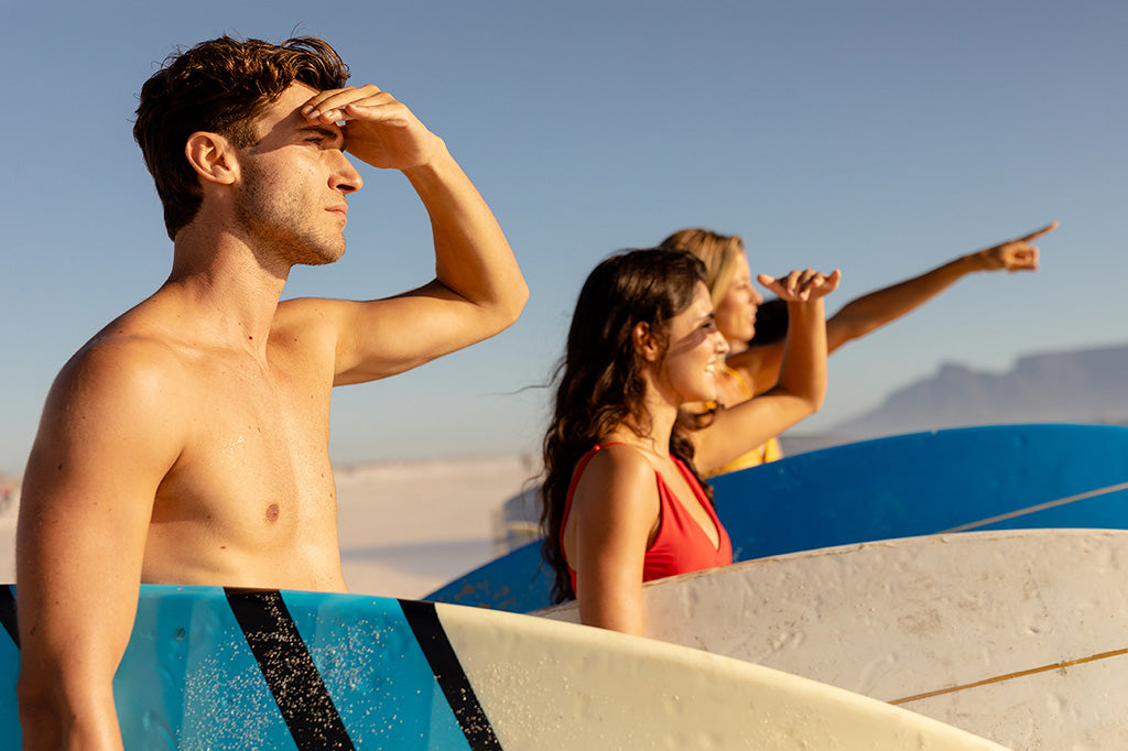 male and female surfers on the beach