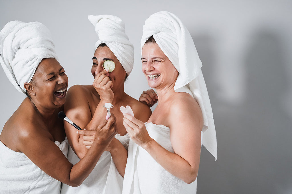 multigenerational women having fun in bathrobe using skincare