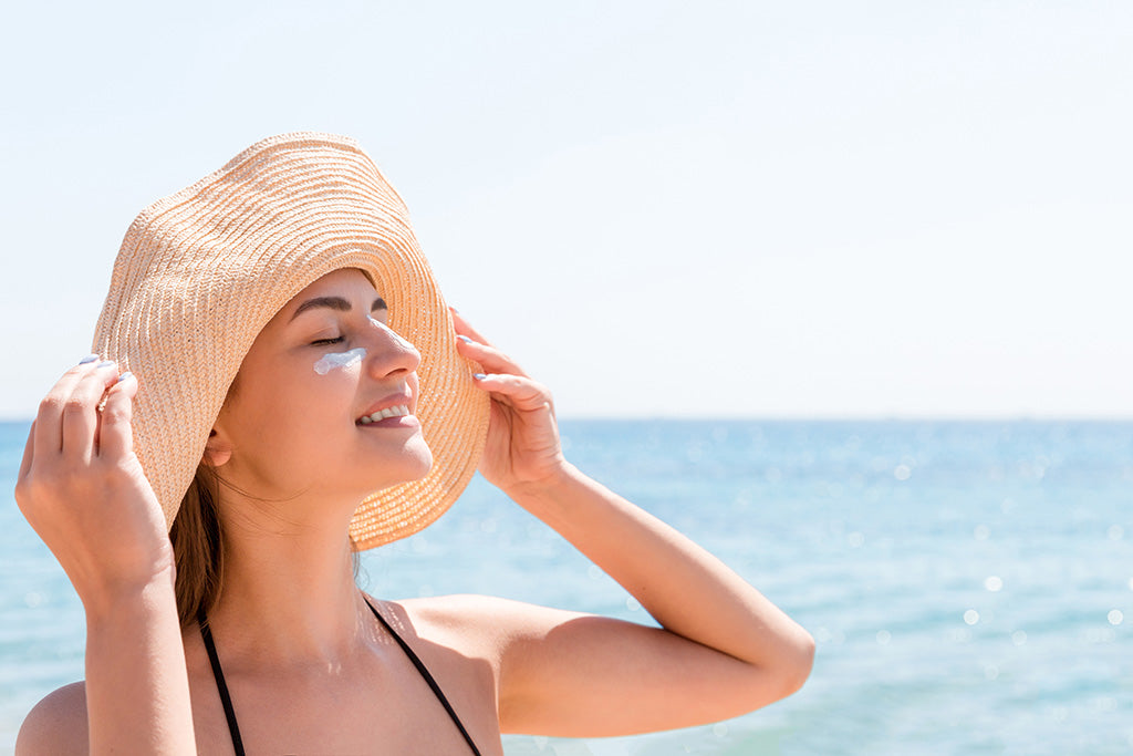 smiling woman wearing a hat enjoying fun under the sun