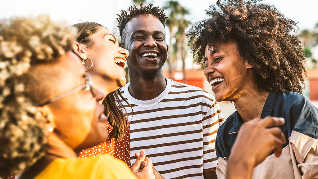 multiracial group of friends laughing together outdoors