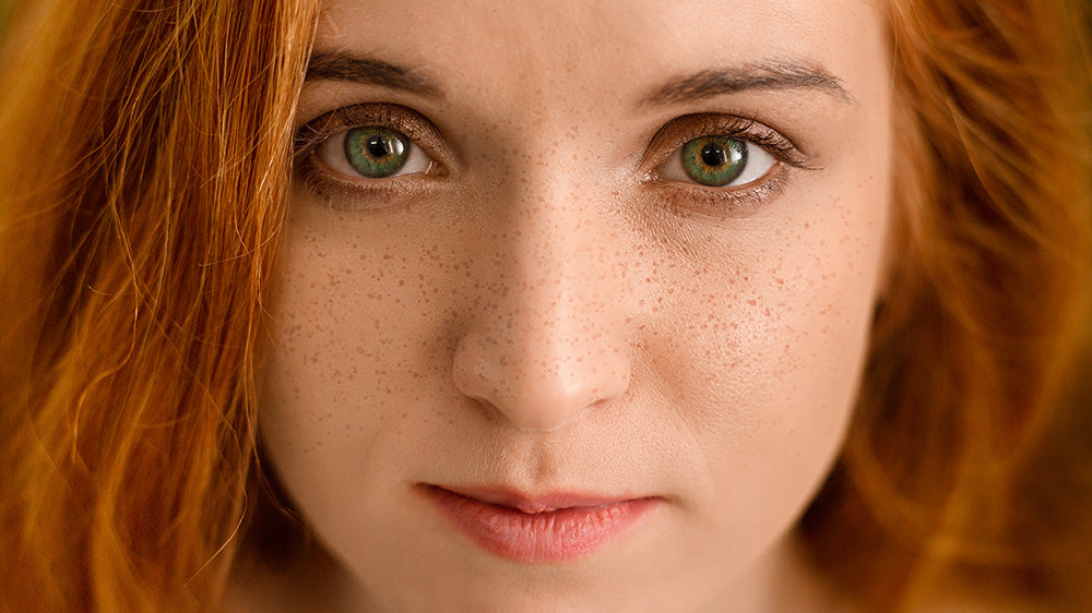 close up of woman with red hair and freckles on face