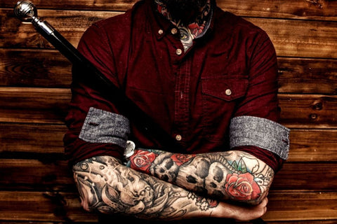 homem com caveiras tatuadas
