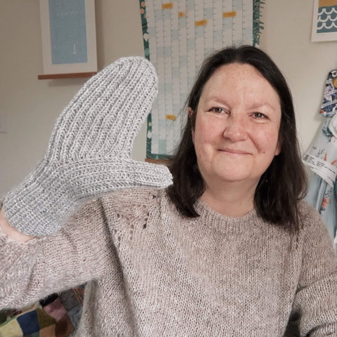 Emma showing a finished handknit mitt