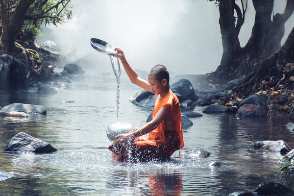 Monk Cleansing an Offering Bowl in River