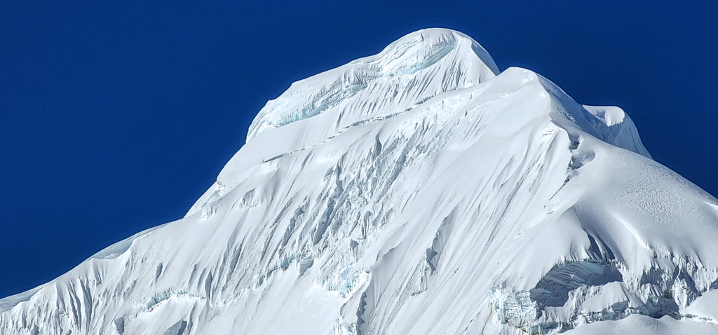 Tocllaraju is a classic climb in the Cordillera Blanca and the hardest part of the climb is at the summit.  It's pictured here above the last few pitches of the West Face.  Cordillera Blanca Peru. Photo: Zeb Blais.