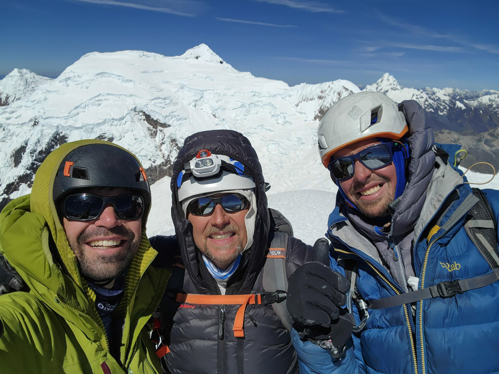 Our team on the summit of Tocllaraju, enjoying mild conditions after the fierce winds at sunrise had subsided. Strong winds often accompany the sunrise in the Cordillera Blanca of Peru and we were glad they died down for the summit! Photo: Zeb Blais.