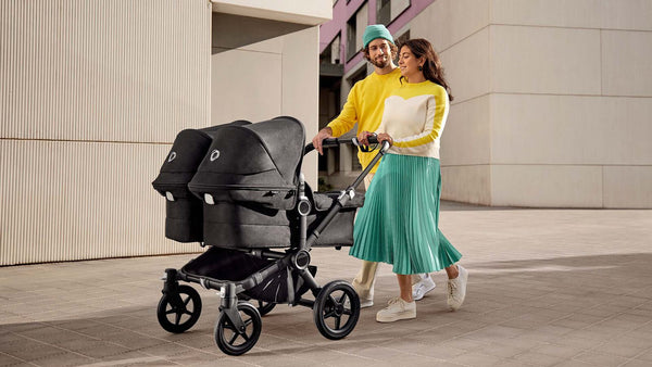 best strollers for twins and multiples - parents push bugaboo donkey 5 stroller down street