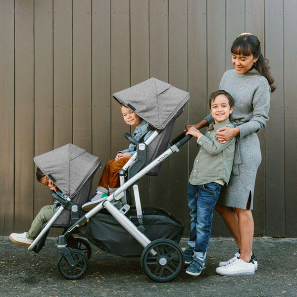 best strollers for twins and multiples - woman pushes uppababy vista v2 stroller with three children