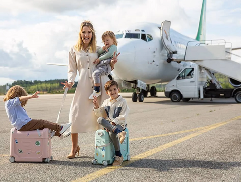 family stands in front of plane to go on vacation with baby