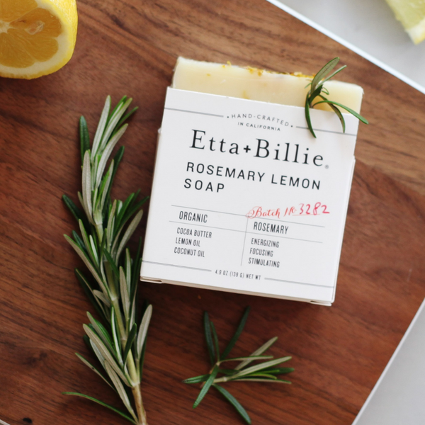 etta + billie rosemary lemon soap on wooden cutting board with fresh herbs