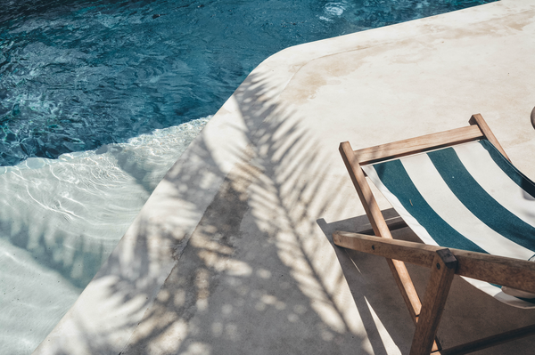 chair in the shade sitting poolside in the summer