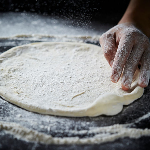 rolling out pizza dough