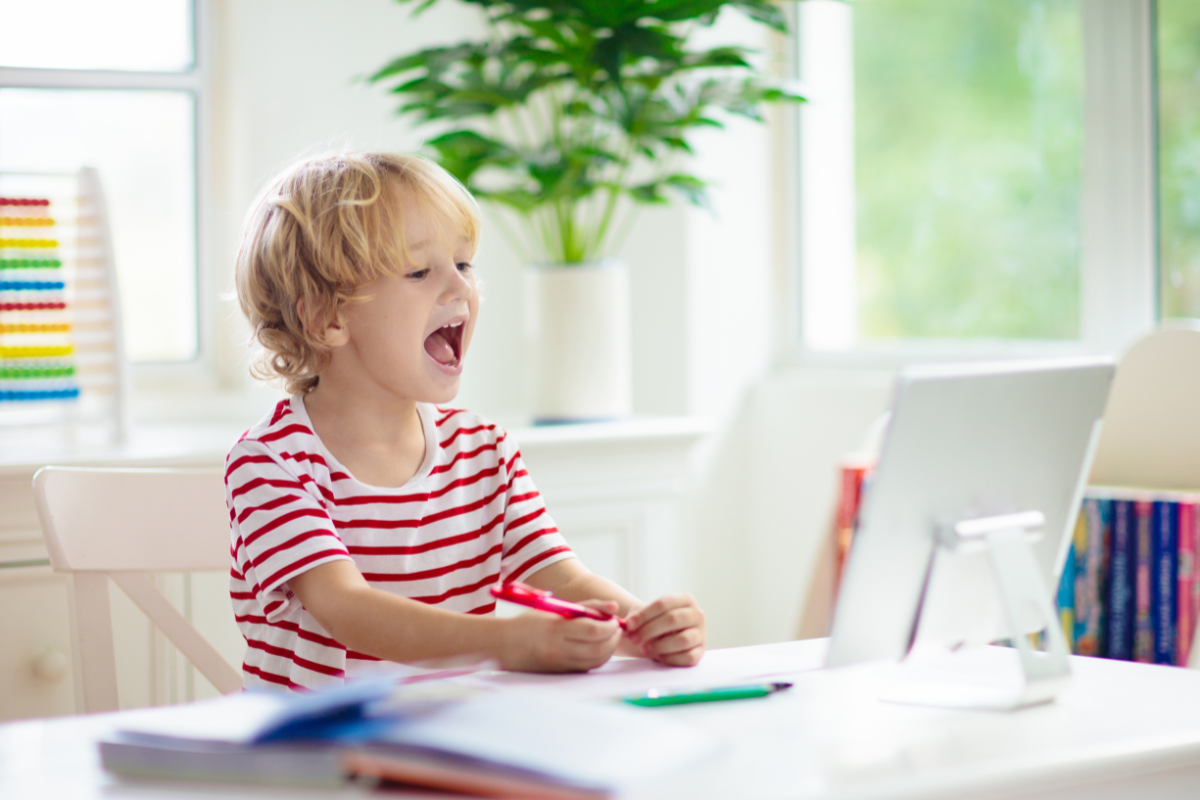 Little boy playing game on computer and happy