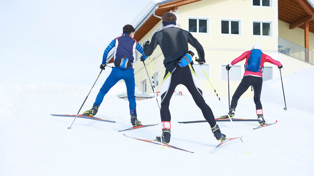 trois skieur de fond montant une pente