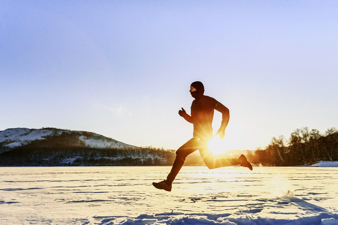 vue latérale d'un homme pratiquant le jogging en hiver en nature.