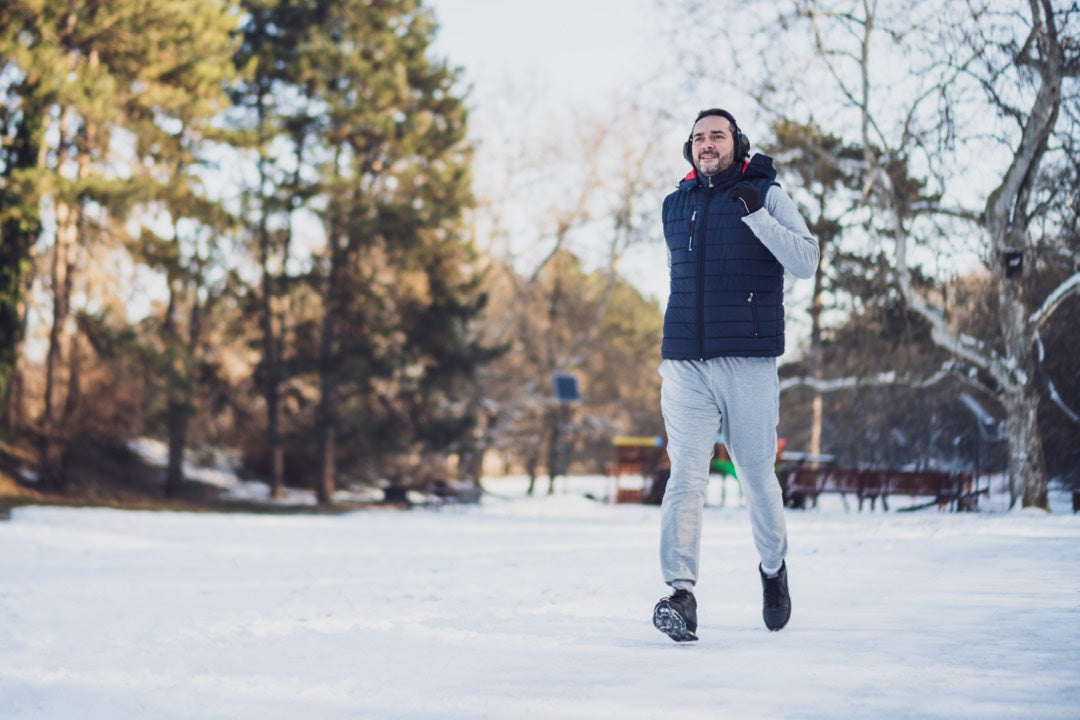 Un homme pratiquant le jogging en hiver sur une terre glacée