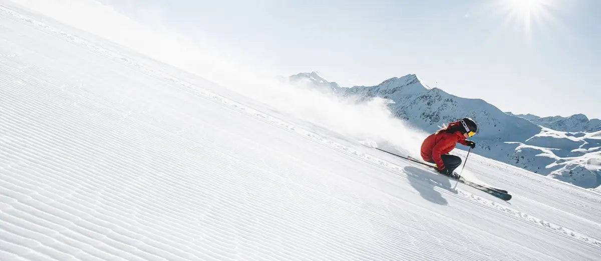 Skieuse faisant du ski alpin en montagne au printemps.