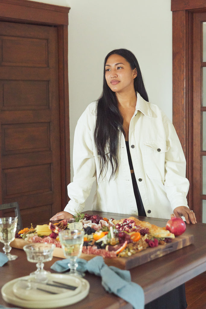 Food artist and TYSM founder Aimee Lennox stands behind her perfect cheeseboard with fruits, nuts, cheeses and meats.