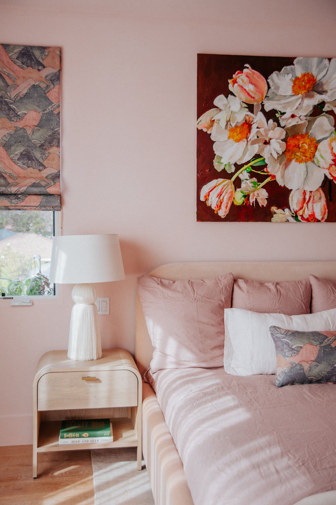 The Samantha white ceramic table lamp sits atop the curved light wood Brooke nightstand next to the pink Solene platform upholstered bed.