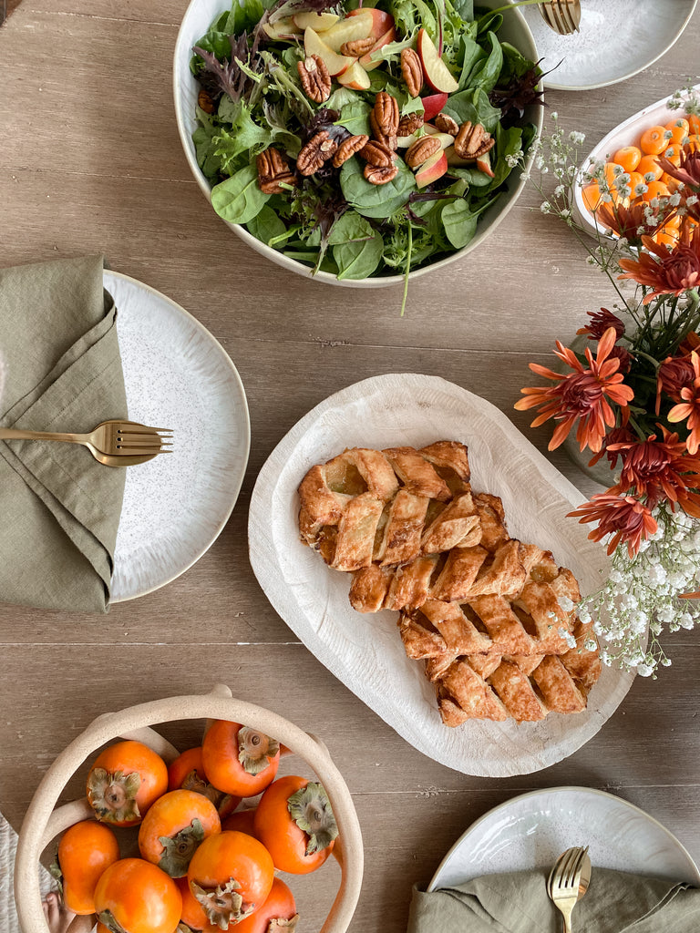 Ascia Sahar's holiday table includes a winter salad, apple hand pies, fresh fruit and persimmons, and a large floral arrangement.