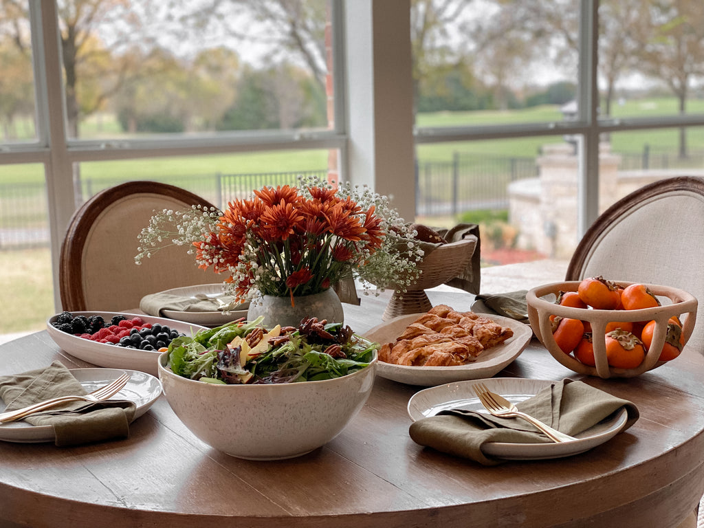 Ascia Sahar's holiday table includes a winter salad, apple hand pies, fresh fruit and persimmons, and a large floral arrangement.