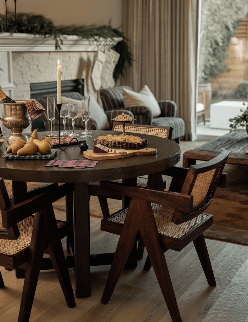 Round dining table with cane back dining chairs set for holiday entertaining.