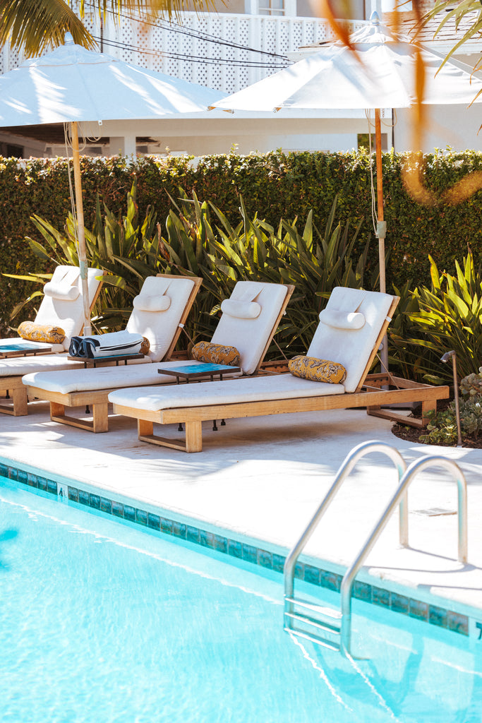 Pool chaise lounge chairs with the Sarah Sherman Samuel Tiger Bolster Pillow.