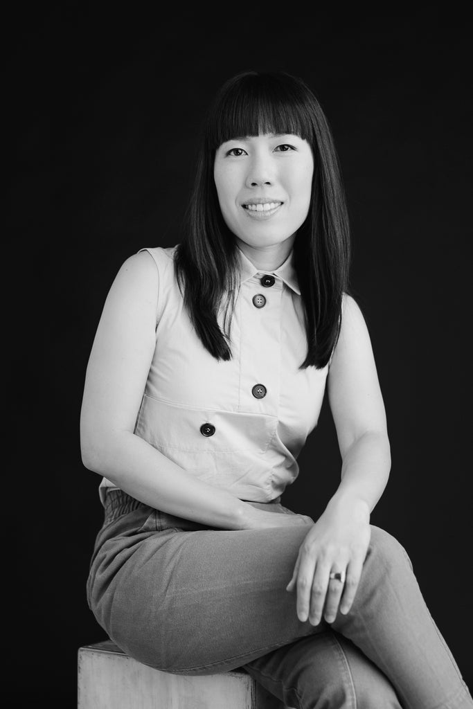 Interior designer Christine Lin smiles in a black and white photo.