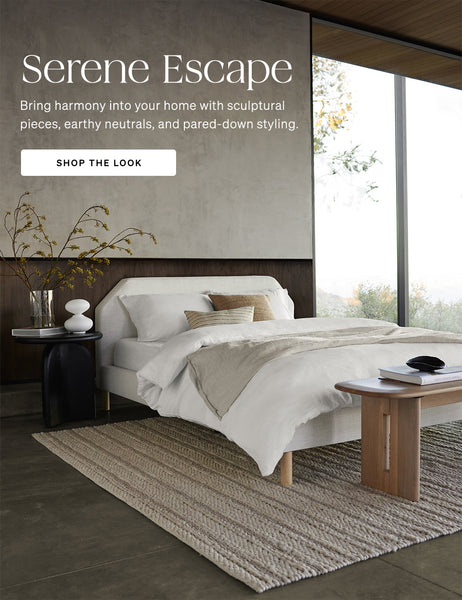 A serene escape bedroom has a white bed, dark walls and wooden accents to bring harmony into your home with sculptural pieces, earthy neutrals and pared-down styling.