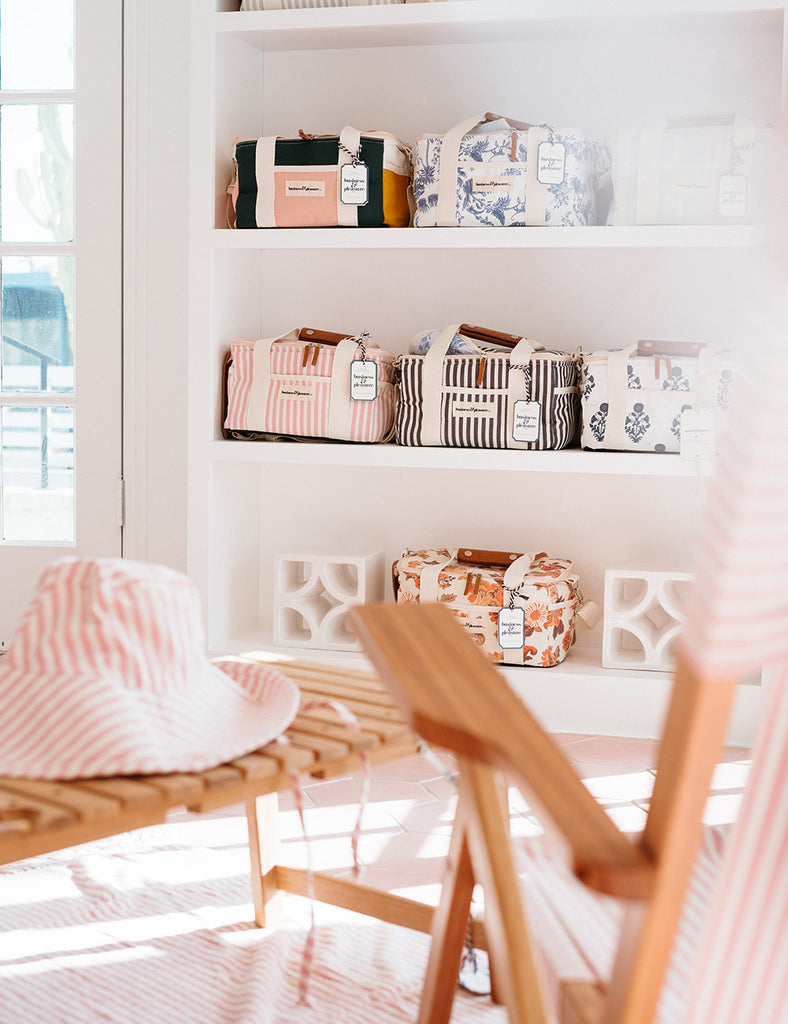 A display wall in Business & Pleasure Co.'s shop holds canvas toiletry bags in various patterns.