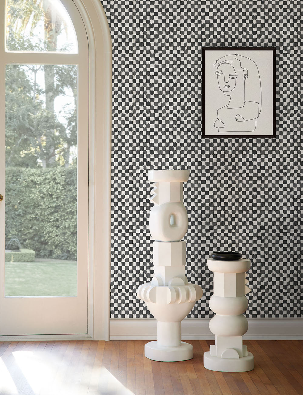 The black and white Checkerboard Wallpaper by Sarah Sherman Samuel sets a modern and eclectic feel with two white sculptures and a black and white line drawing.