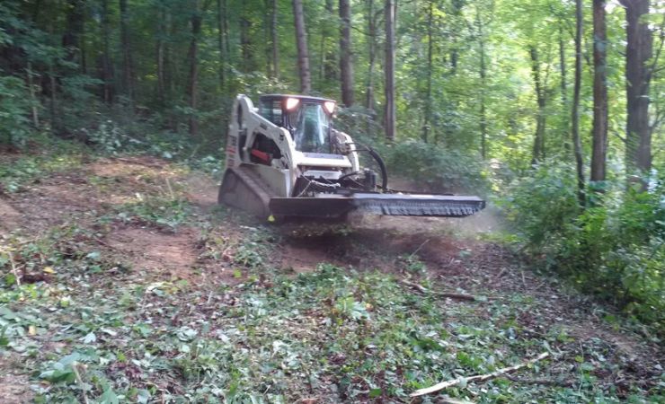 bobcat skid steer brush cutting on a hill