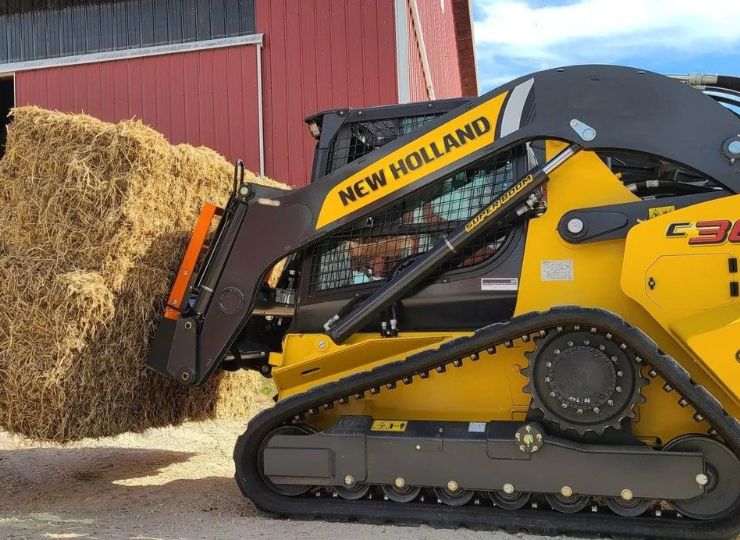 skid steer with tracks and a bale spear attachment