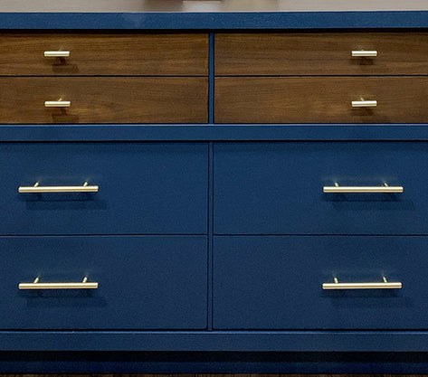Cosmas brushed brass hardware on woodgrain and blue dresser