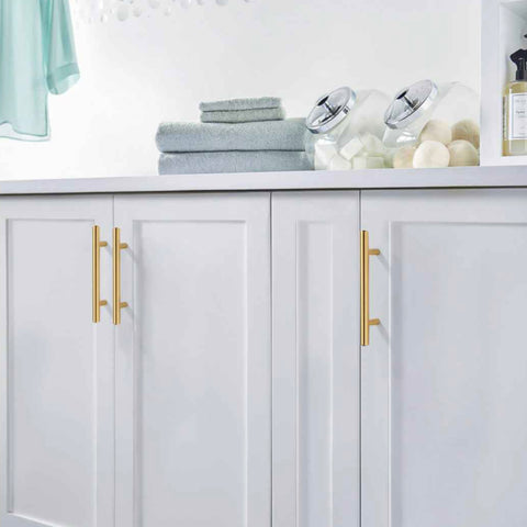 Diversa brushed brass euro bar pulls on white bathroom cabinets