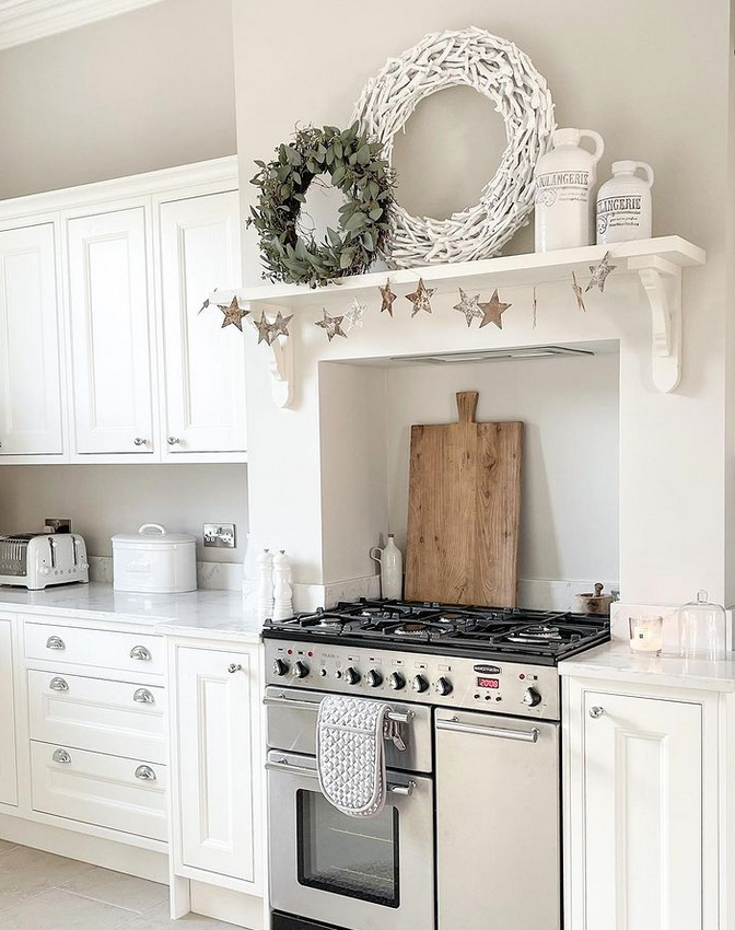 Chrome Pulls in white kitchen with staineless steel range, white counter tops, white cabinets, and some chrome accents. 