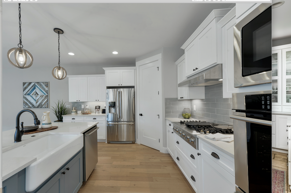 Large kitchen with oil rubbed bronze fixtures and cabinet cup pulls on white and blue cabinets. The kitchen has stainless steel appliances