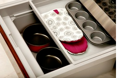 Kitchen toe kick drawer with pans and other kitchen items are stored