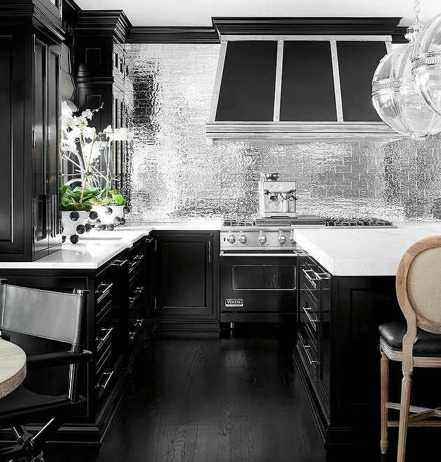 FLashy dramatic black kitchen with mirror backsplash and satin nickel cabinet pulls